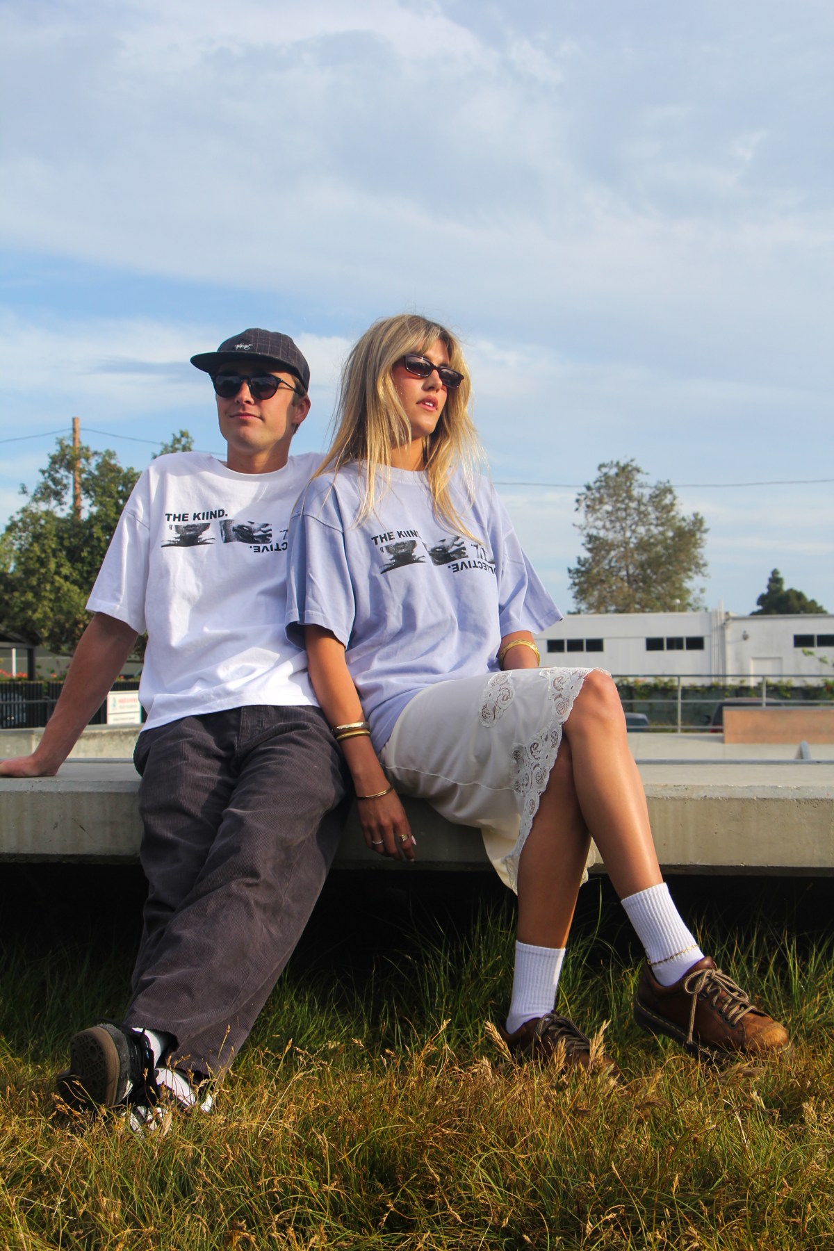 Two models sitting outdoors wearing Collective V1 shirts