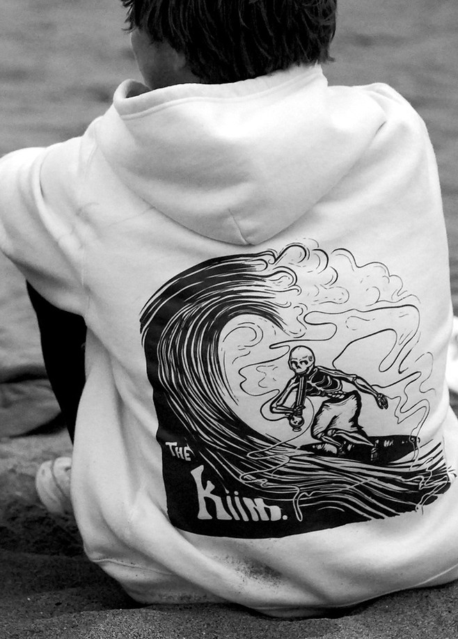 Stoned to the Bone hoodie worn outdoors, showing the skeleton wave artwork